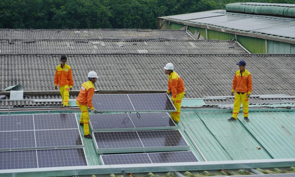 pexels-photo-11645008-11645008 Workers installing solar panels on a roof for sustainable energy solutions.